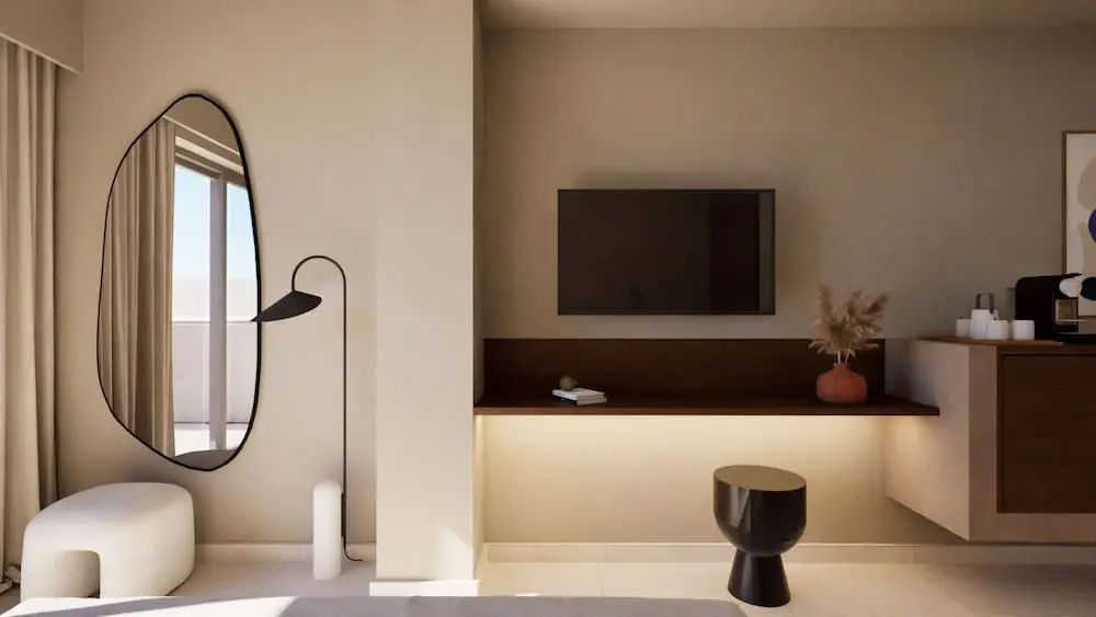 Wandbereich im Hotelzimmer mit Flachbildfernseher, Schreibtischablage und Hocker.