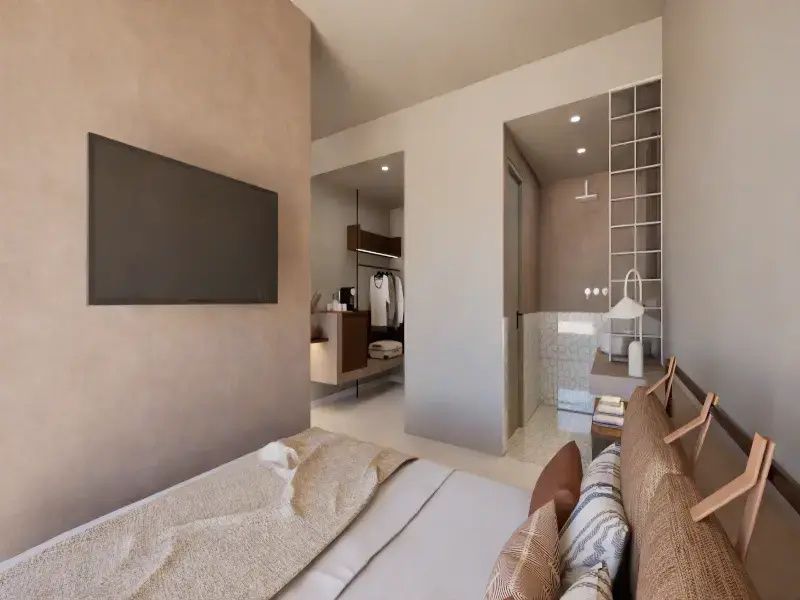 Blick vom Bett auf den Fernseher an der Wand und den Flur mit Schrankbereich.