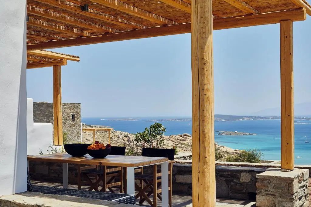Überdachte Terrasse mit Esstisch aus Holz und Weitblick über die Küstenlandschaft.