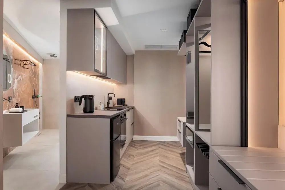 Küchenzeile mit Wasserkocher und offener Kleiderschrank in der Suite.