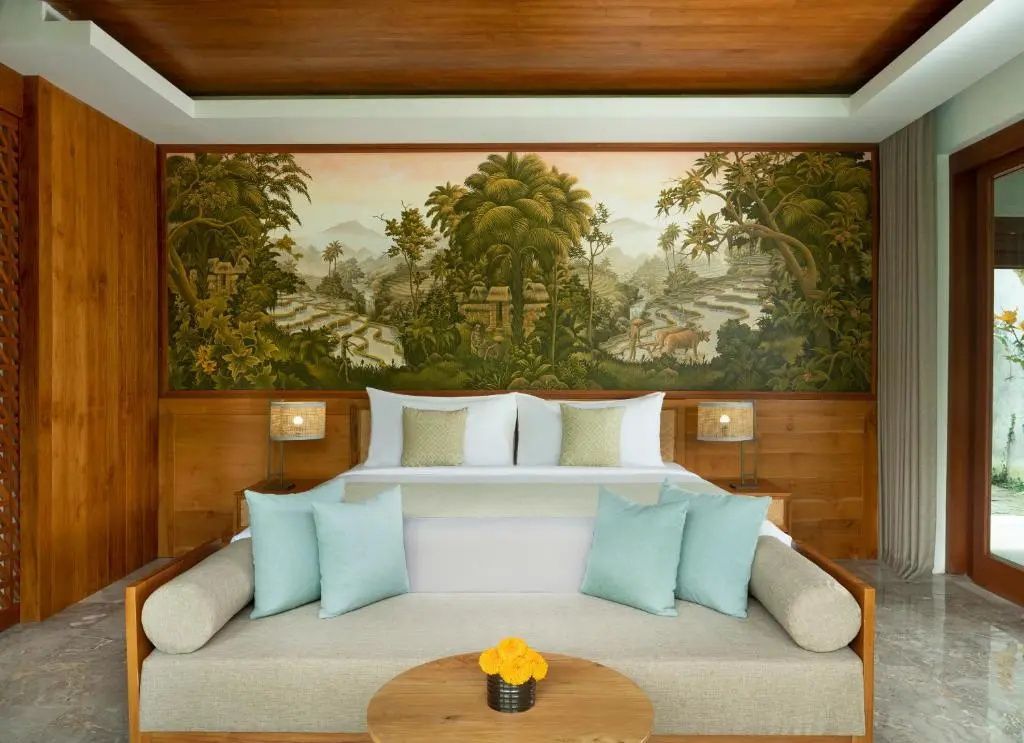 Schlafzimmer mit Doppelbett, Wandgemälde einer Landschaft und Holzverkleidung.