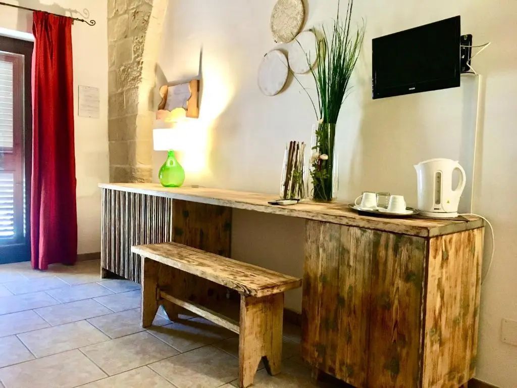 Holztisch mit einer Holzbank, Fernseher an der Wand und Dekoration im Zimmer.