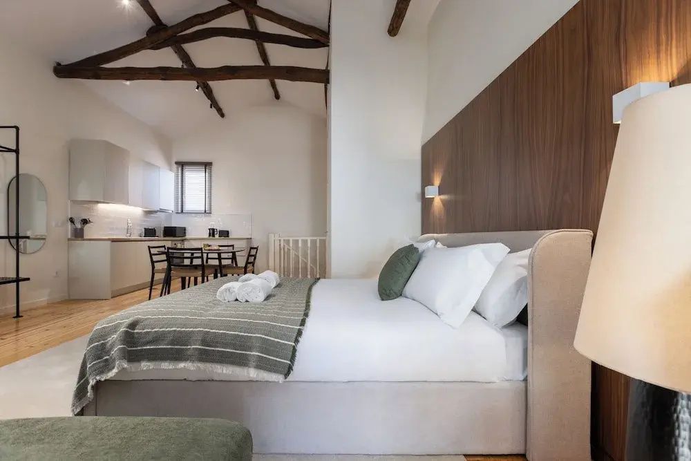 Geräumiges Apartment mit Holzbalken an der Decke und Blick auf die Küche.