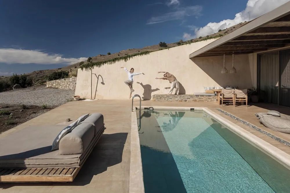 Sonnige Terrasse mit privatem Pool, Liegefläche und überdachtem Esstisch im Freien.