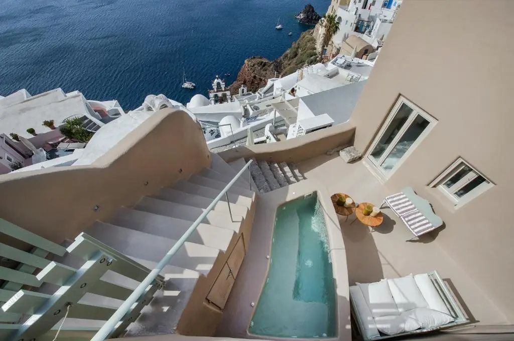 Terrasse mit schmalem Pool und freiem Blick auf das tiefblaue Meer sowie die Klippen.