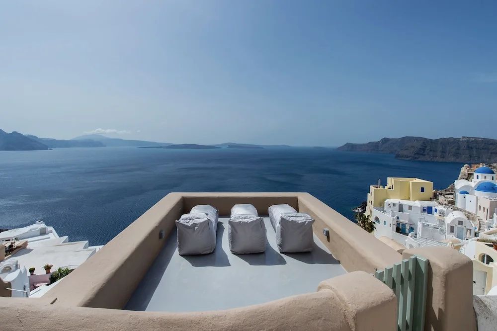 Dachterrasse mit drei Liegekissen und weitem Panoramablick über das blaue Meer.