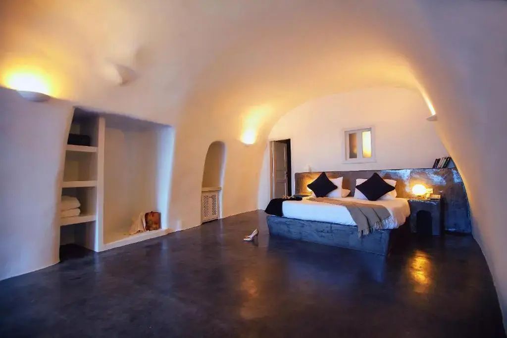 Schlafbereich einer Höhlensuite mit gewölbter Decke und warmer Beleuchtung.
