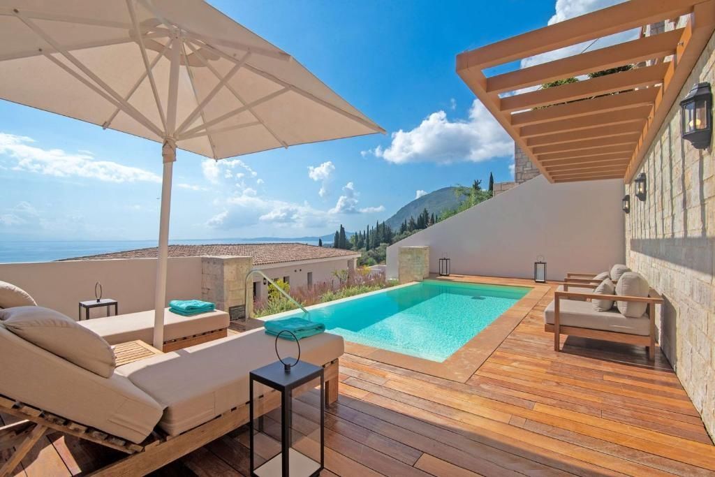 Sonnendeck mit privatem Pool, zwei Sonnenliegen, Sonnenschirm und Blick auf das Meer.