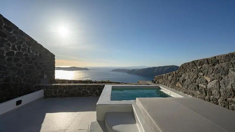 Sonnendurchflutete Terrasse mit Whirlpool und Panoramaaussicht auf das Meer.