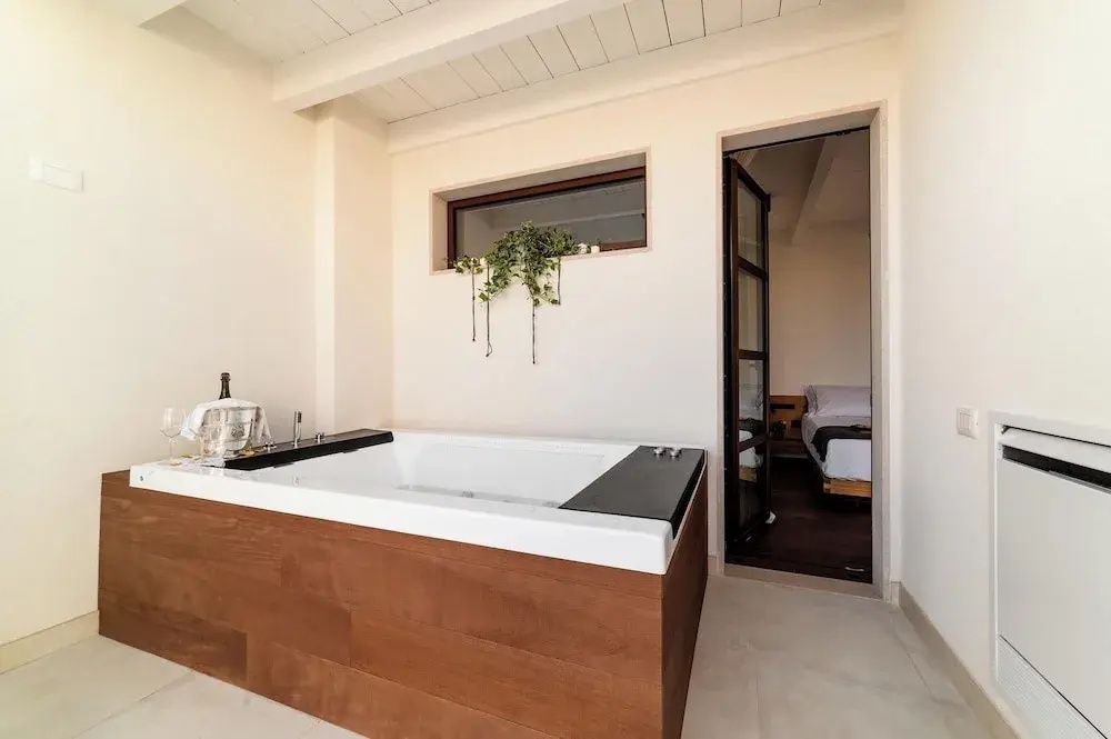 Moderner Whirlpool mit Holzverkleidung neben dem Eingang zu einem Schlafzimmer.