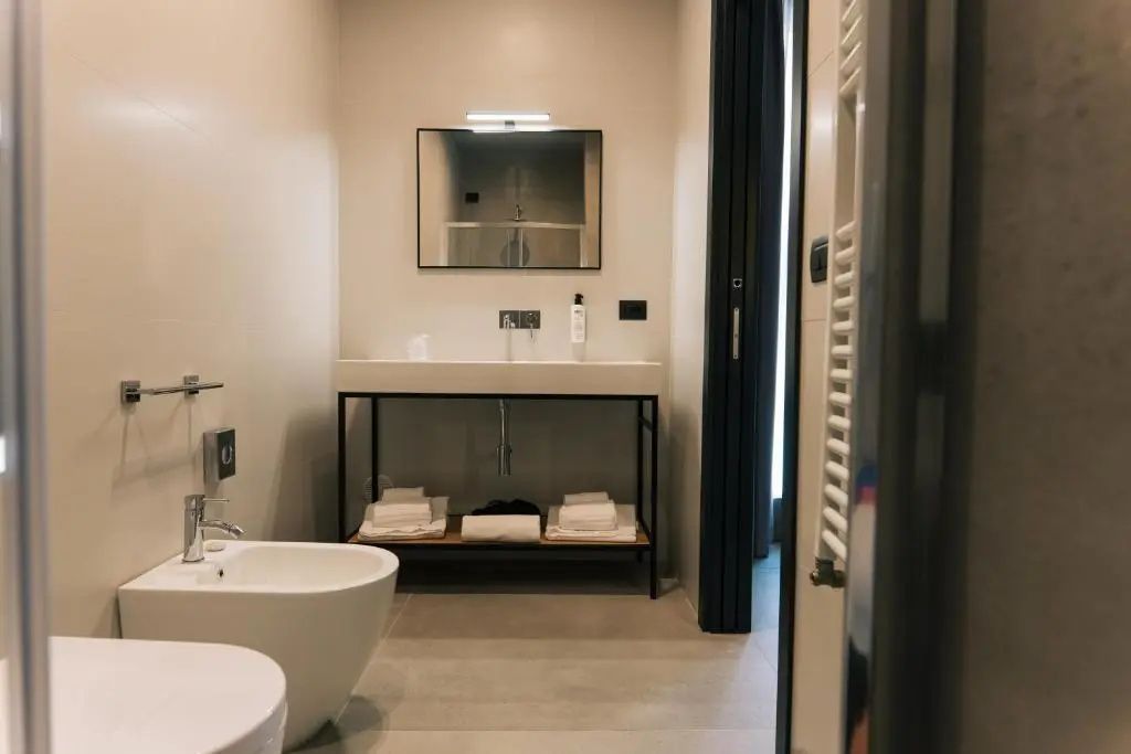 Modernes Badezimmer mit Waschtisch auf Metallgestell, Spiegel und Bidet.