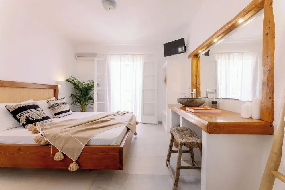 Ein modern eingerichtetes Zimmer mit Holzmöbeln, Waschbecken und Balkontür.