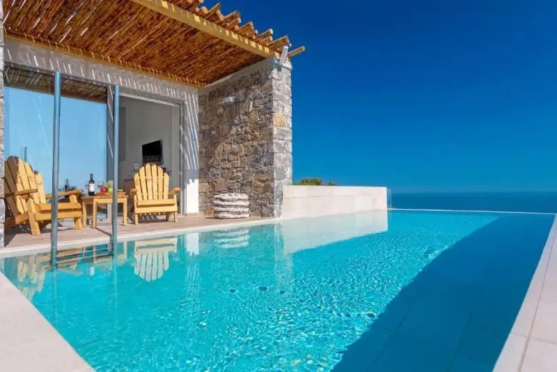 Pool auf einer Terrasse mit Holzüberdachung und direktem Blick auf das blaue Meer.