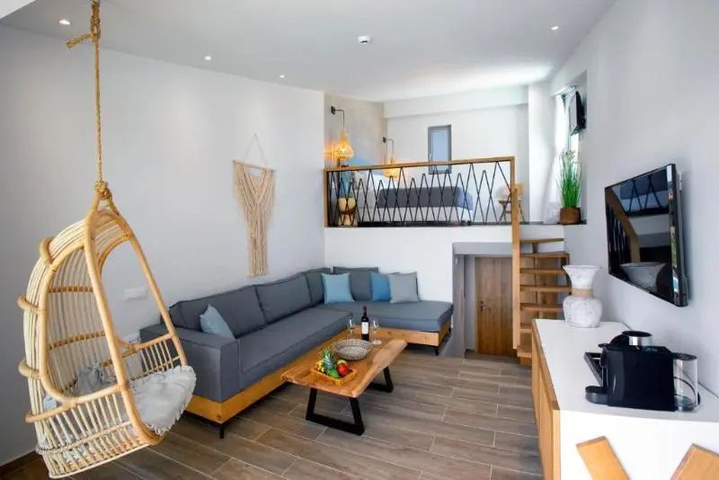 Zweigeschossiges Zimmer mit großem Ecksofa, Holztisch und Treppe zur Galerie.