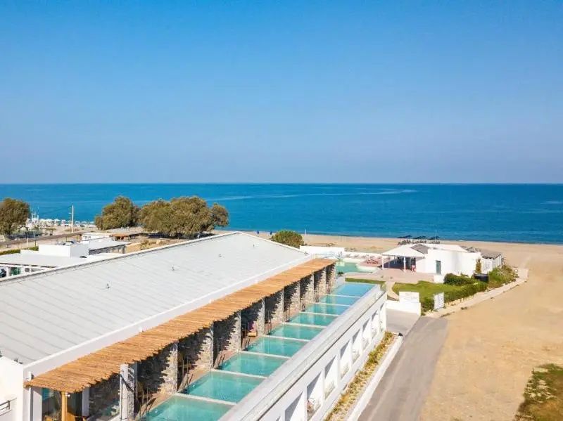 Draufsicht auf die Hotelanlage mit privaten Pools direkt am Sandstrand und Meer.