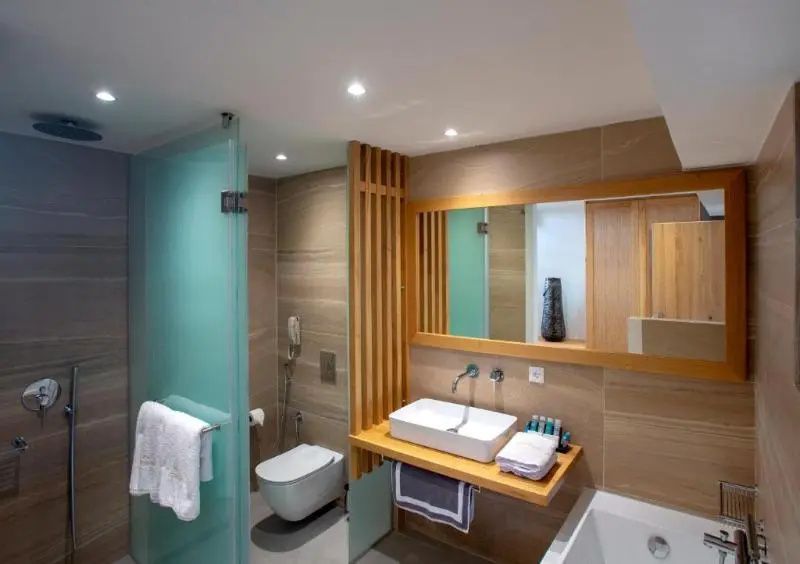 Modernes Badezimmer mit Waschbecken auf Holztisch, Dusche mit Milchglas und WC.