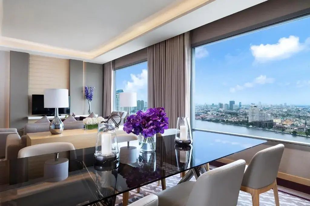 Esstisch im modernen Wohnbereich einer Suite mit Blick auf Fluss und Stadt.