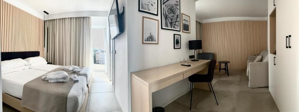 Schreibtischbereich mit Tischlampe, Wandbildern und Flachbildfernseher im Zimmer.