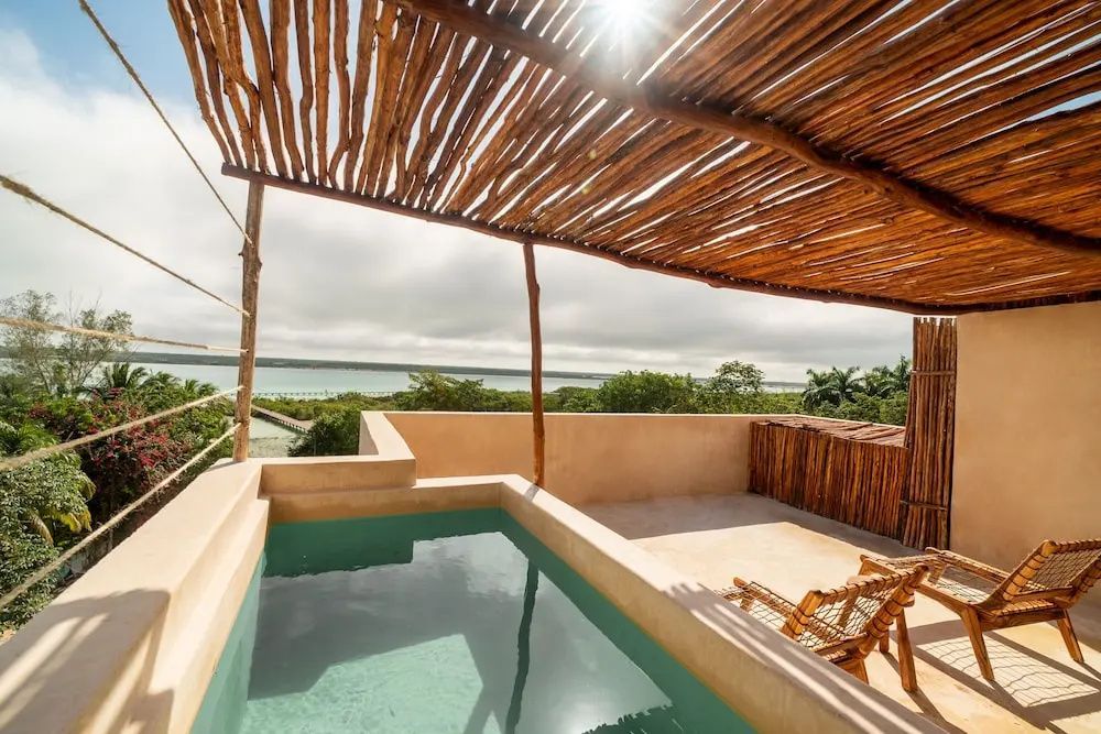 Dachterrasse mit kleinem Pool, Holzdach und Blick auf die umliegende Natur und das Wasser.
