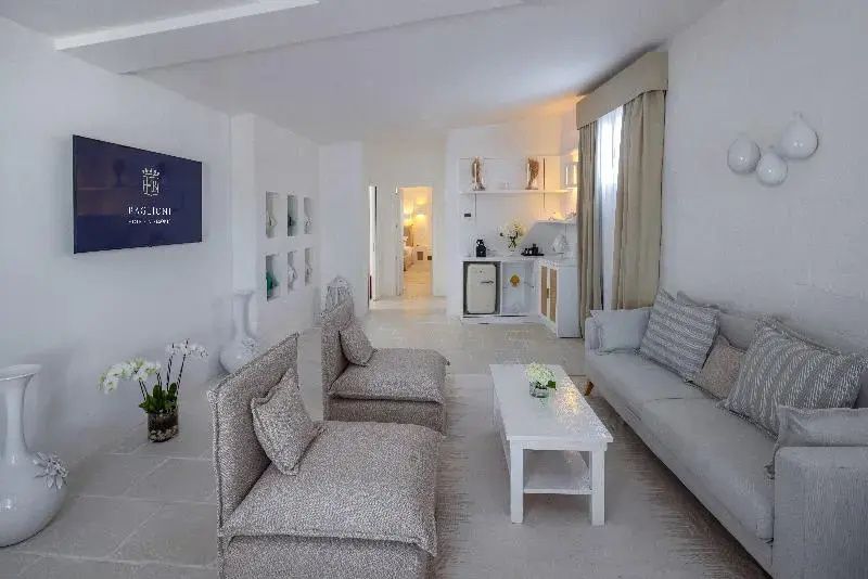 Heller Wohnbereich einer Suite mit grauem Sofa, Sesseln und einem weißen Couchtisch.