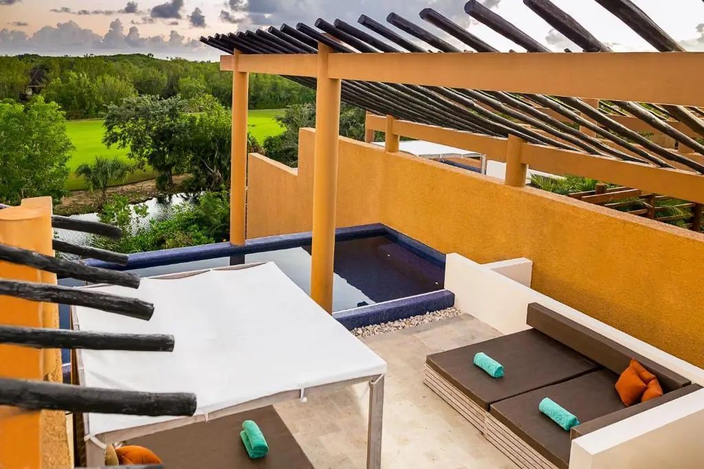 Dachterrasse mit kleinem Pool, Liegestühlen und Blick auf die grüne Landschaft.