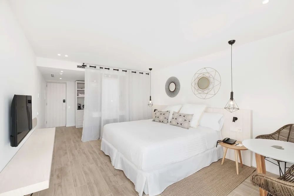 Großzügiges Doppelzimmer mit hellem Holzfußboden und transparenter Abtrennung