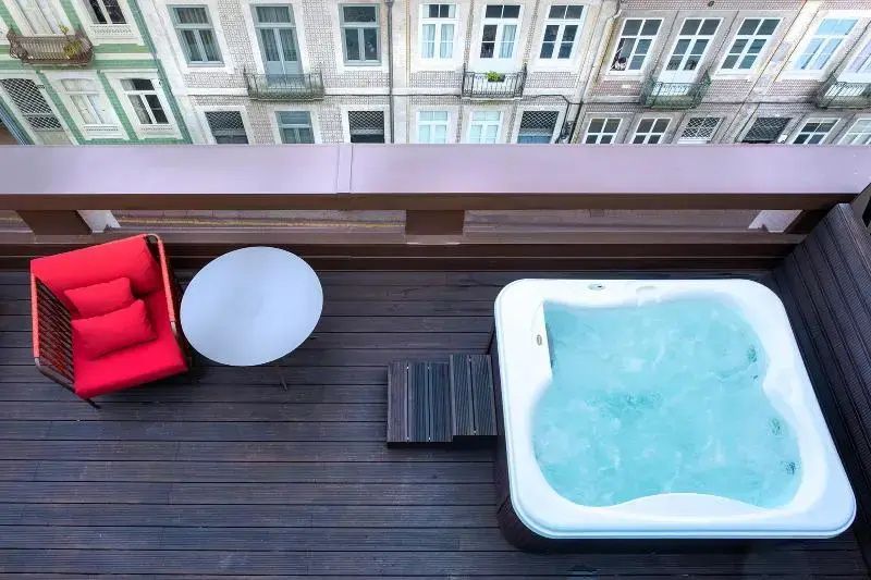 Dachterrasse mit Whirlpool und Holzfußboden sowie Blick auf historische Häuser.