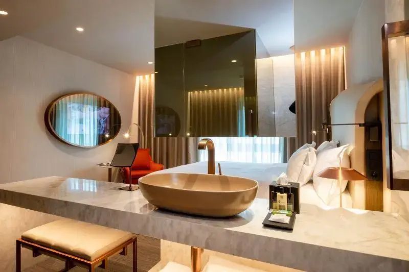 Waschtischbereich im Hotelzimmer mit freistehender Waschschale und Spiegel.