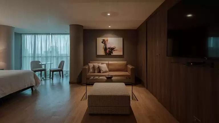 Gemütlicher Sitzbereich im Hotelzimmer mit braunem Ledersofa und Wandbild.