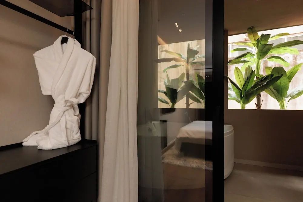 Blick durch das Apartment mit Bademantel und Bett im Hintergrund.