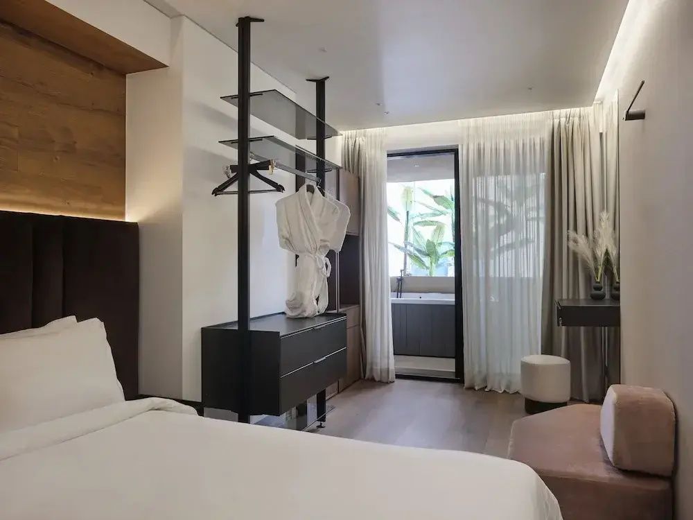 Modernes Hotelzimmer mit offener Garderobe und Zugang zur Terrasse