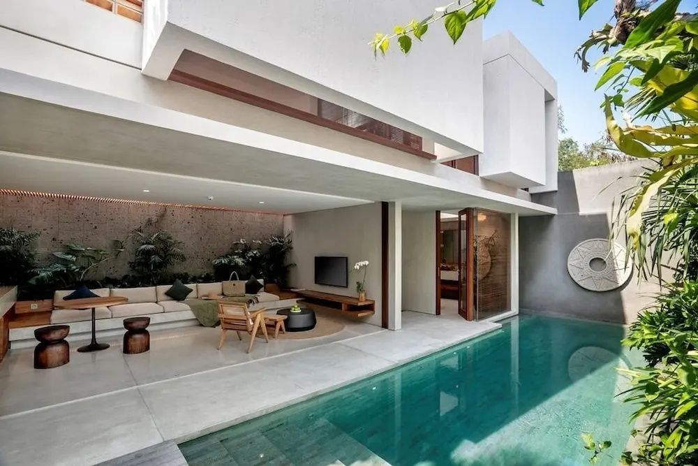 Moderne zweistöckige Villa mit offenem Wohnbereich, Sitzgruppe und eigenem Pool.