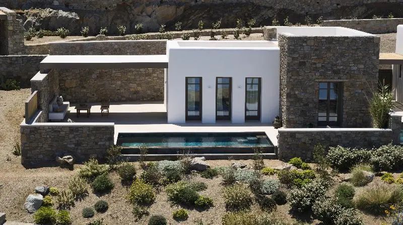 Außenansicht einer modernen Villa mit Natursteinelementen und einem privaten Pool.
