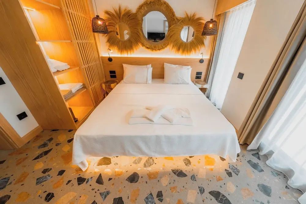 Doppelbett mit beleuchtetem Untergestell und runden Spiegeln an der Wand.