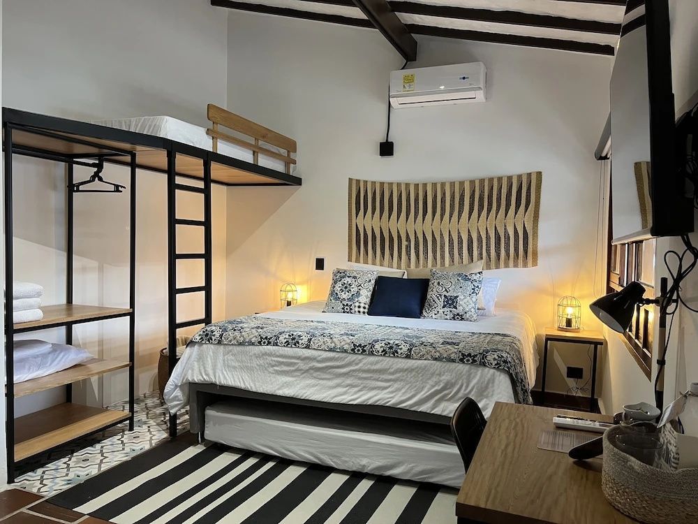 Schlafbereich mit Doppelbett, Ausziehbett, Hochbett und offenem Kleiderschrank.