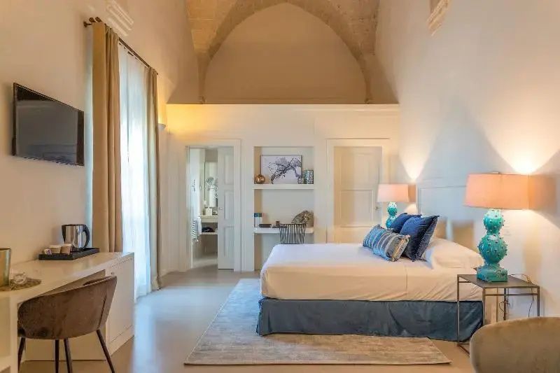 Hotelzimmer mit hohem Kreuzgewölbe, Schreibtischnische und Blick ins Badezimmer.