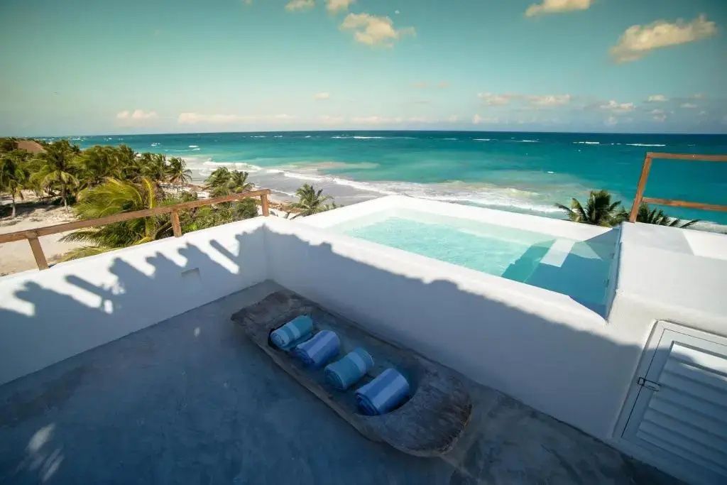 Dachpool auf einer weißen Terrasse mit direktem Blick auf den Strand und das blaue Meer