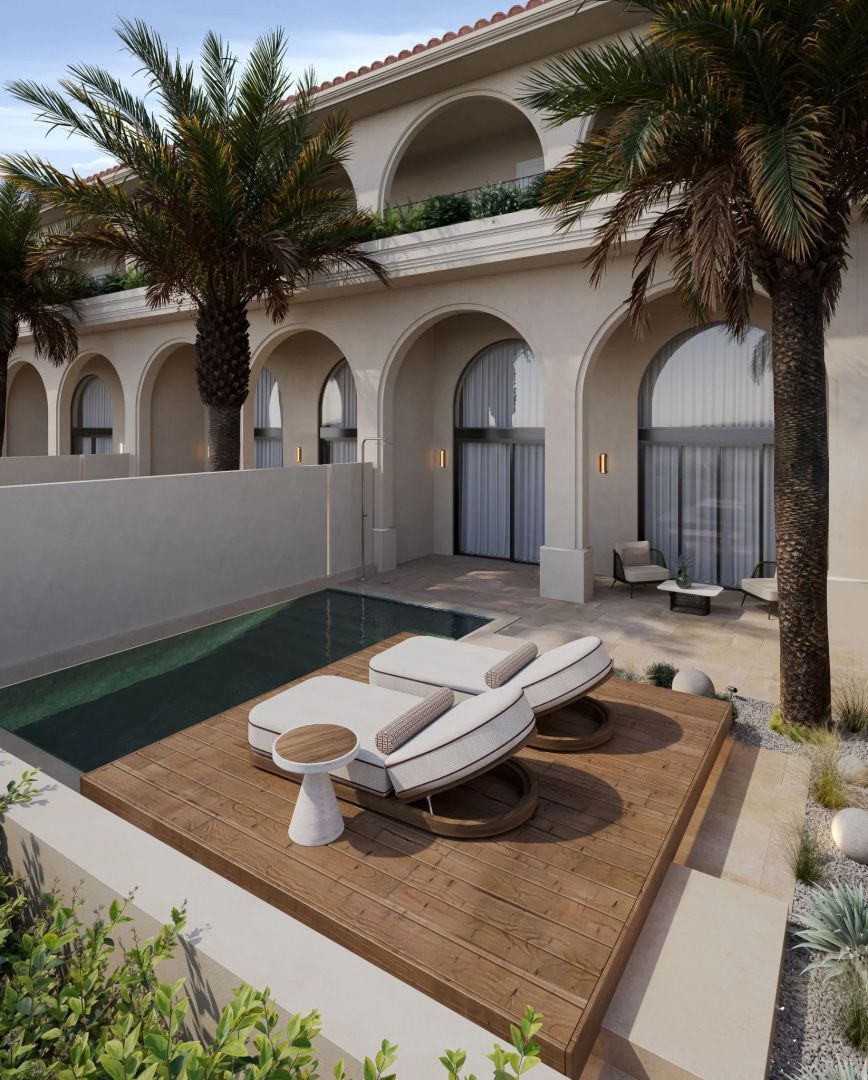 Terrasse mit privatem Pool, zwei Sonnenliegen auf Holzdeck und Blick auf Hotelbögen mit Palmen.
