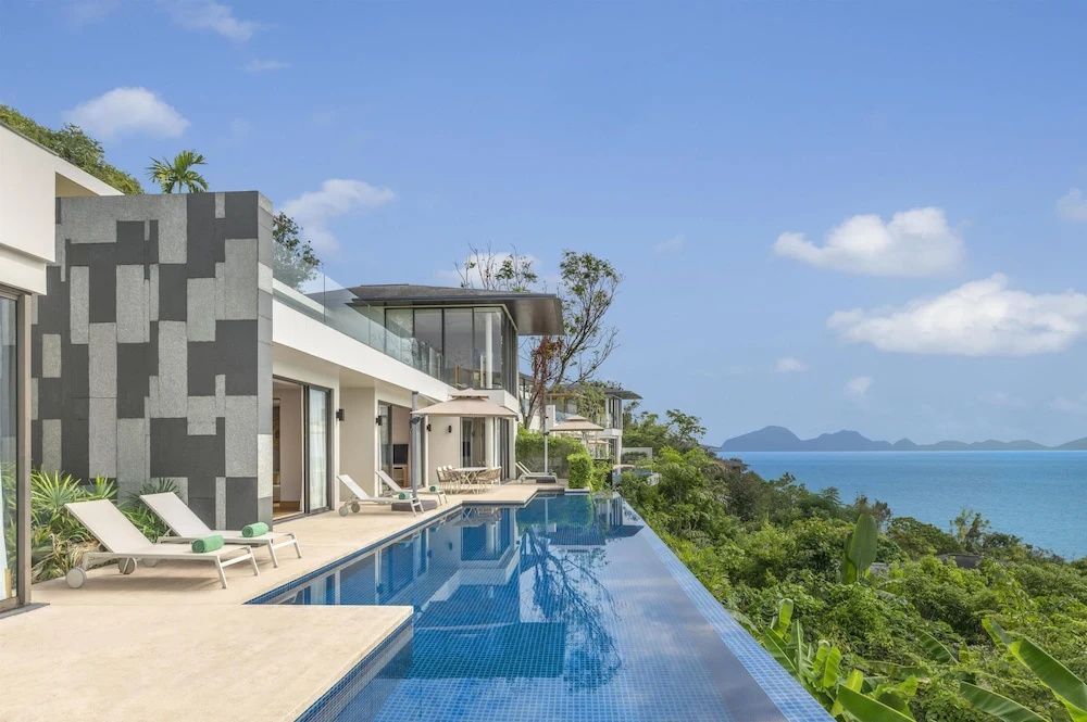 Privater Pool einer Villa am Hang mit weitem Blick auf den Ozean und den Himmel.