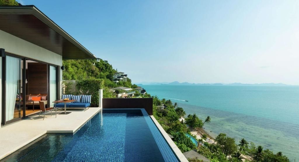 Pool an einem grünen Hang mit weitem Blick auf die Küste und das blaue Meer.