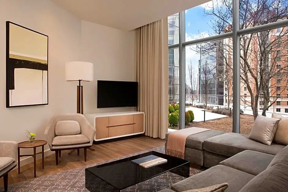 Wohnbereich einer Suite mit Sofa, schwarzem Couchtisch und bodentiefer Fensterfront.