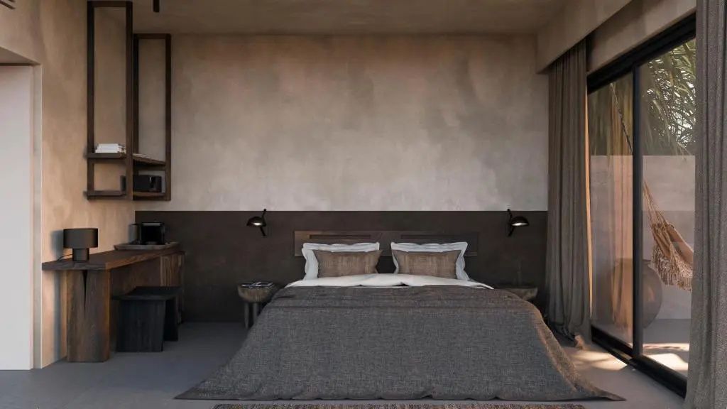 Doppelbett mit brauner Tagesdecke und Kissen vor einer dunklen Wand mit Leseleuchten.