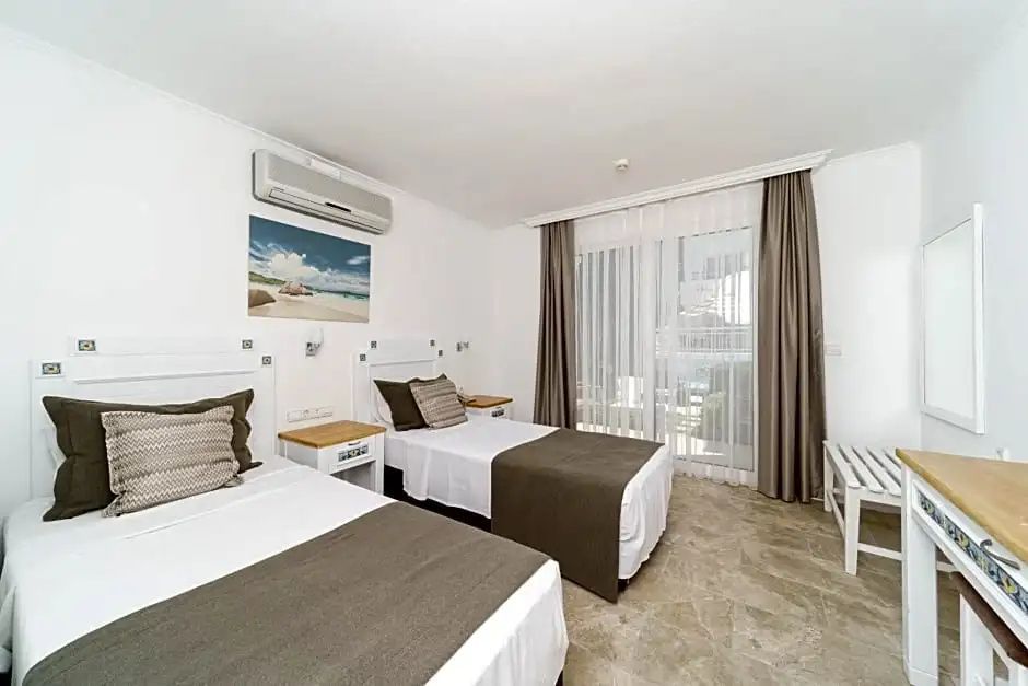 Hotelzimmer mit zwei Einzelbetten, Klimaanlage und großem Fenster zum Balkon.