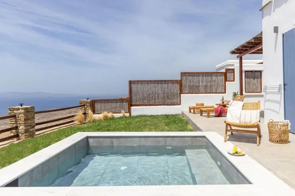 Außenbereich mit kleinem Pool, Rasenfläche, Sonnenliegen und Blick auf das Meer