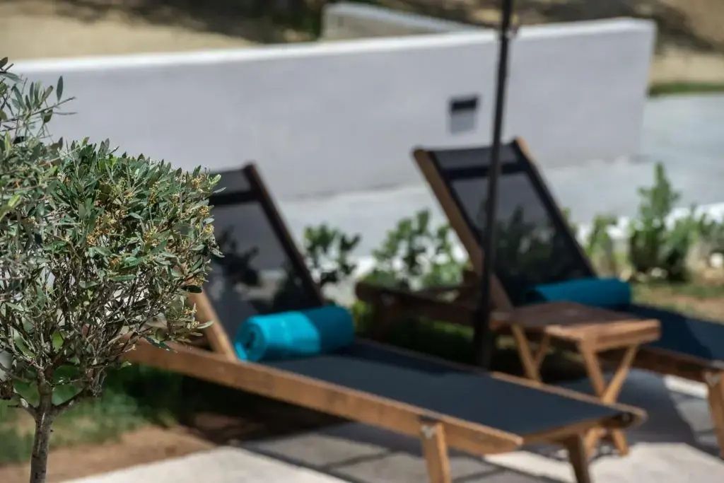 Zwei Sonnenliegen aus Holz mit blauen Handtüchern auf der Terrasse