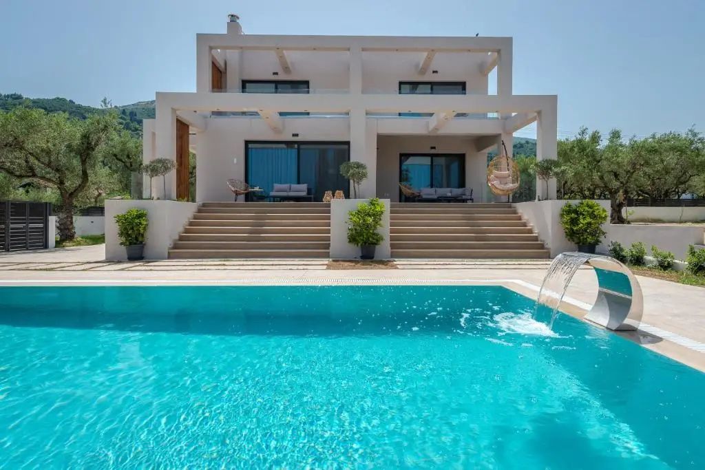 Moderne zweistöckige Villa mit Terrasse, Außentreppen und Pool bei Tageslicht.