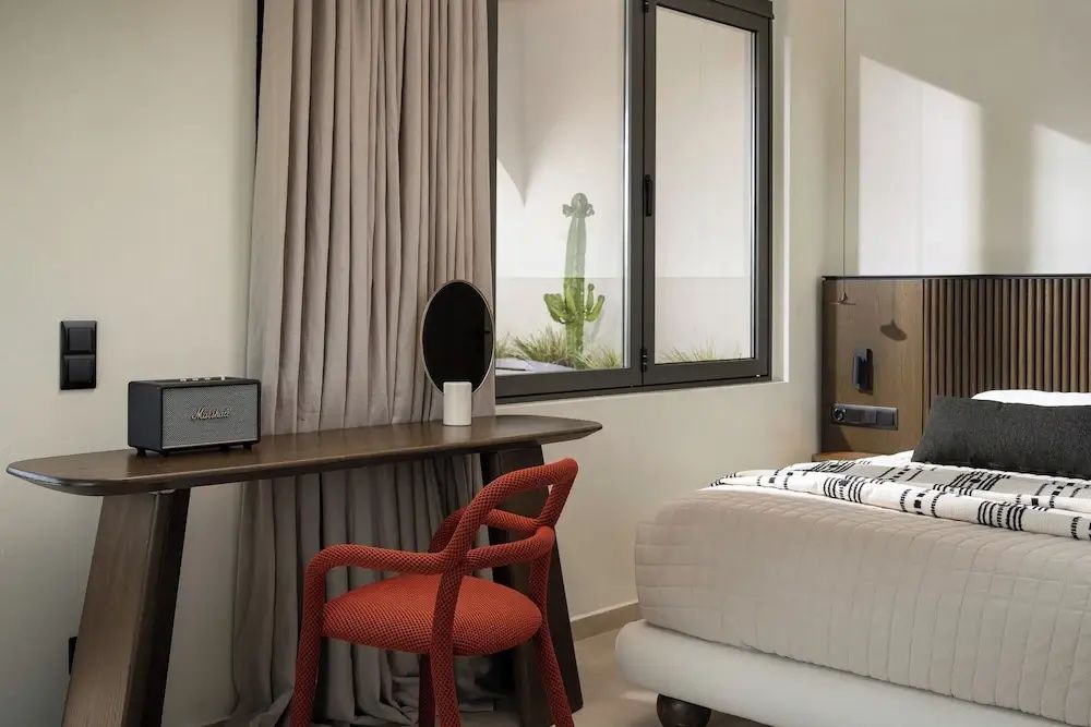 Ein dunkler Holztisch mit einem roten Stuhl und Vorhängen im modern eingerichteten Zimmer.