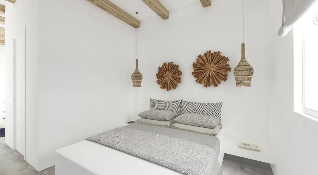 Doppelbett mit grauer Tagesdecke, Holzdeckenbalken und dekorativer Wanddekoration aus Holz.