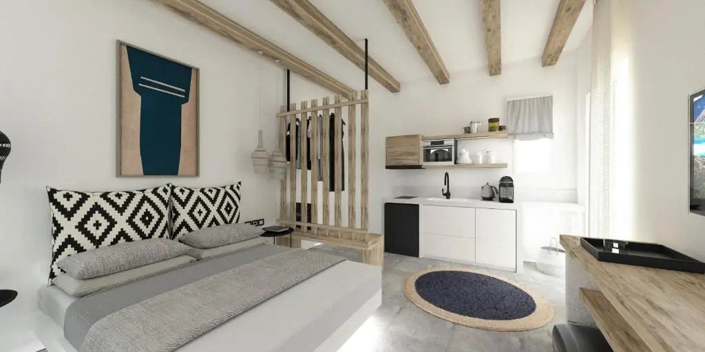 Helles Studiozimmer mit Doppelbett, hölzernem Raumteiler und integrierter Küchenzeile.