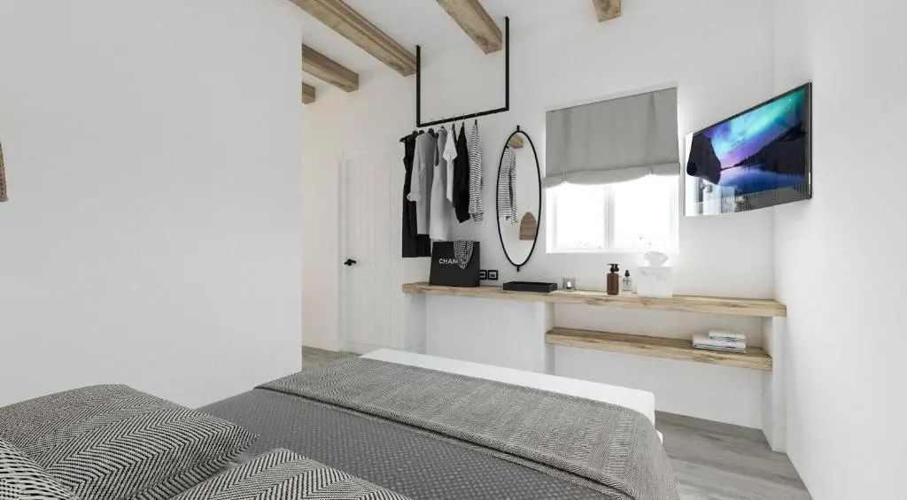 Helles Zimmer mit Garderobe, ovalem Spiegel, Holzregalen und Holzbalken an der Decke.